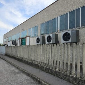 Unità esterne di climatizzazione installate lungo la parete di un edificio industriale