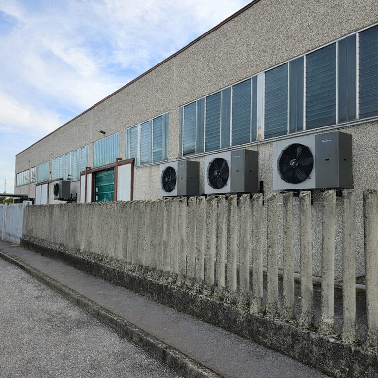 Unità esterne di climatizzazione installate lungo la parete di un edificio industriale