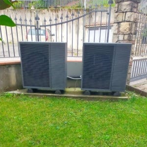 Due unità esterne di pompe di calore su basamenti in un giardino