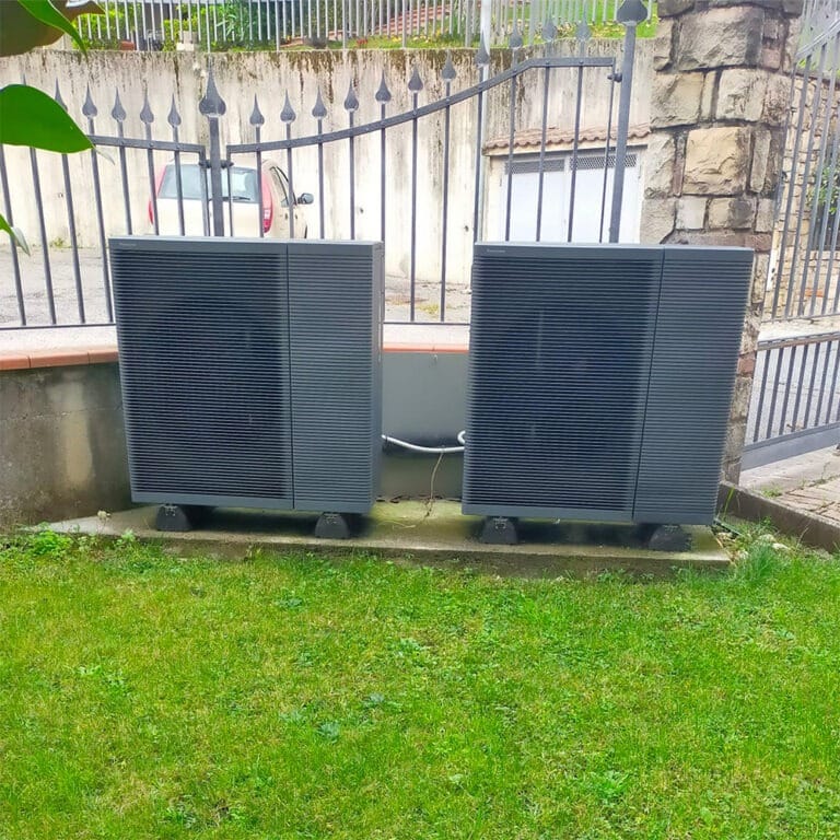 Due unità esterne di pompe di calore su basamenti in un giardino